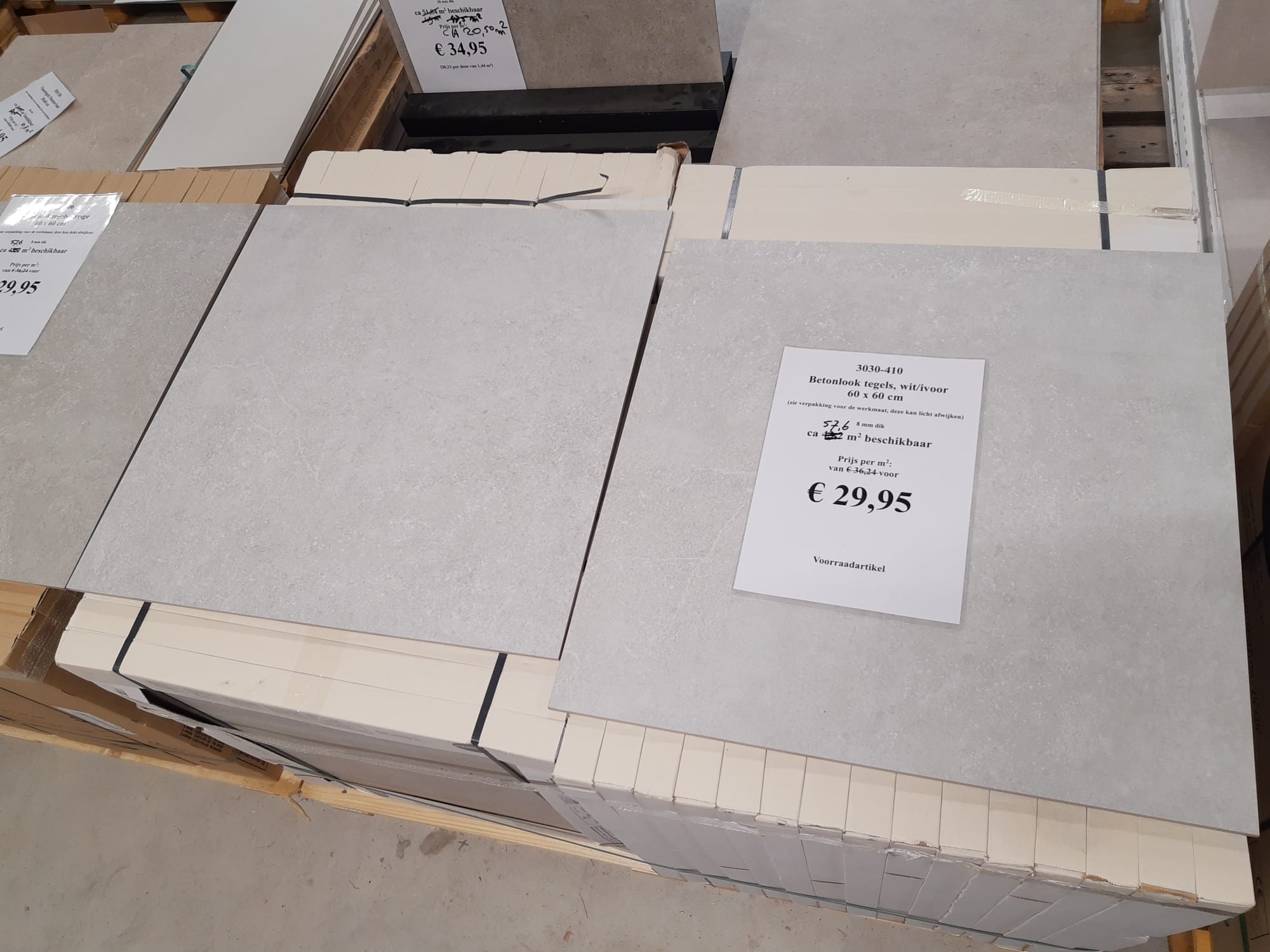 Wit-grijze betonlook tegels van 60x60 cm in het verkoopmagazijn van Tegelstudio Zeeland. Uit voorraad leverbaar